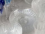 many different colored glasses on a white table