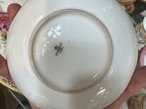 a person holding a bowl and a plate on a table