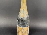 a bottle of champagne on a black table with a gray background