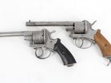 two revolvers are shown on a white surface with a wooden handle