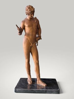 bronze statue of a man holding a knife on a marble base