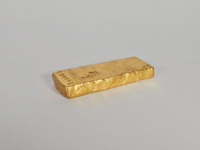 une barre d'or posée sur une surface blanche