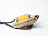 a small bag with a strap on it sitting on a white surface