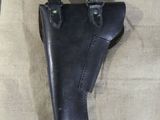 a black leather holster on a tan cloth