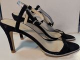 black and silver high heeled shoes with a bow on the toe