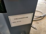a sign on the side of a machine that says tyre changer arm