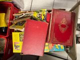 une pile de livres posée par terre à côté d'une chaise