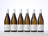 six bouteilles de vin sont alignées sur une table