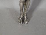 a silver statue of a woman holding a bowl of food