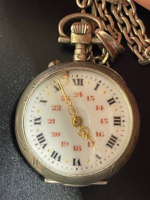 someone is holding a pocket watch with roman numerals on it