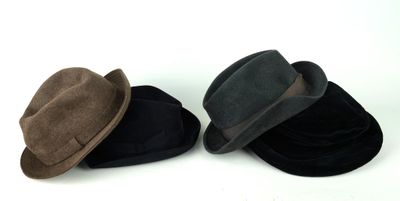 two hats sitting next to each other on a white surface