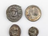 trois pièces romaines, dont l'une représente la tête d'un homme et deux autres la tête d'un