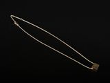 un collier en or avec un pendentif de forme carrée au bout d'une chaîne