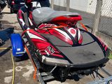 a red and black jet ski being towed by a trailer