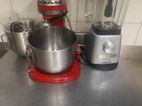 un mixeur rouge posé sur un plan de travail de cuisine, avec un bol mixeur