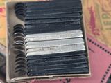 a box with a bunch of black and silver pencils in it