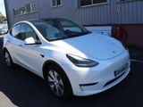 a white tesla car parked in front of a building