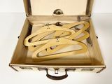 six pairs of shoes in a suitcase on a white surface