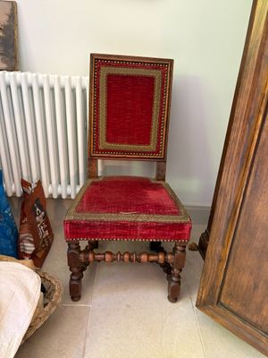 a red chair sitting in a room next to a white radiator