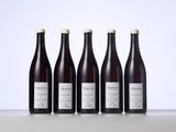 four bottles of wine are lined up on a table