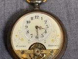 une vieille montre de poche à laquelle est accrochée une chaîne sur le côté