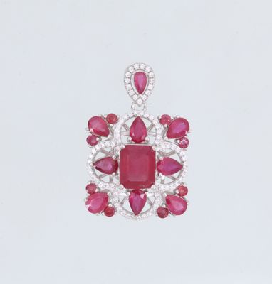 un gros plan d'un pendentif en rubis et diamants sur fond blanc