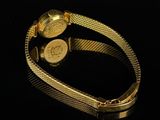 an image of a gold wrist watch on a black surface