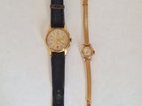 an image of a couple of watches sitting on top of a white surface