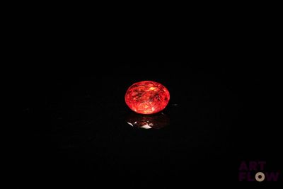 une image représentant une balle rouge dans l'obscurité, sur fond noir