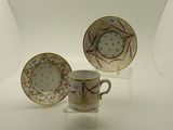 trois tasses et une soucoupe posées sur une table