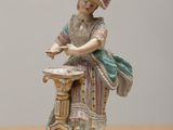 a figurine of a woman sitting on a table