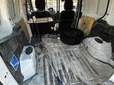 the inside of a van with the door open and the floor covered in dirt
