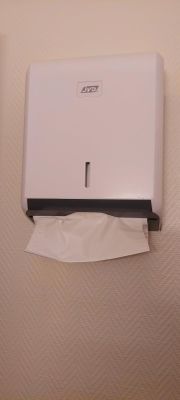 un distributeur de papier toilette fixé au mur à côté d'un autre distributeur de papier toilette