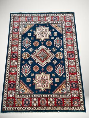 un tapis bleu avec une bordure rouge et un fond blanc