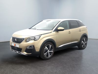 La voiture beige est garée dans une pièce au sol noir.