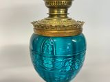 a blue vase with a gold lid on a table