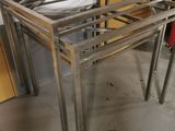 a metal table with a glass top in the middle of a room