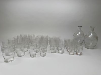 des bouteilles et des verres sont alignés en rang sur une surface blanche