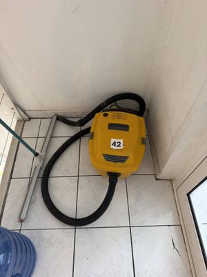 un sèche-cheveux jaune posé par terre près d'une fenêtre