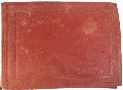 un vieux livre rouge posé sur une surface blanche