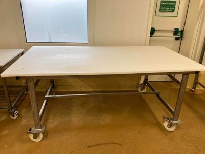 une table blanche munie de roulettes dans une pièce