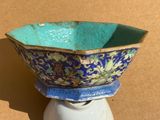 a blue and green bowl sitting on top of a white stand