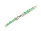 un gros plan d'un bracelet en perles vertes sur fond blanc