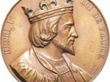 an image of a gold medal with a man wearing a crown on it