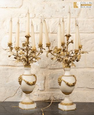 two white and gold vases with candles on a table