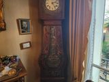 une horloge de parquet dans un coin de la pièce, près d'une fenêtre
