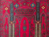 a red rug with a blue and green design on it