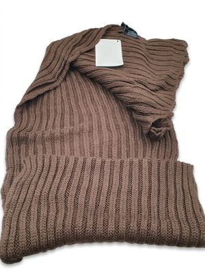 un gros plan d'une couverture tricotée marron sur fond blanc
