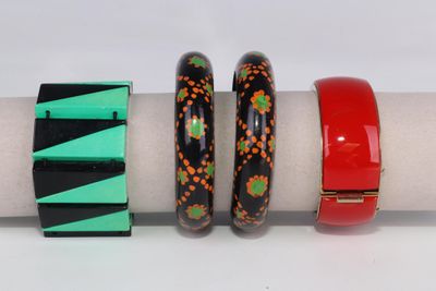 trois bracelets de couleurs différentes posés sur une serviette, elle-même posée sur une surface blanche