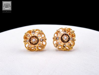 paire de boucles d'oreilles dorées ornées de diamants sur un fond blanc